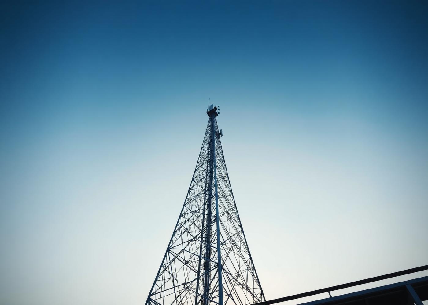 Tower technicians working together on antenna equipment at height